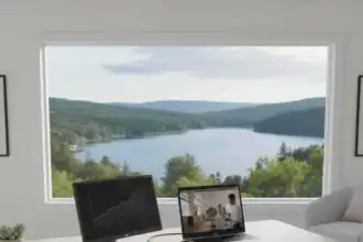 Bright home office overlooking lush forest and tranquil lake scenery.