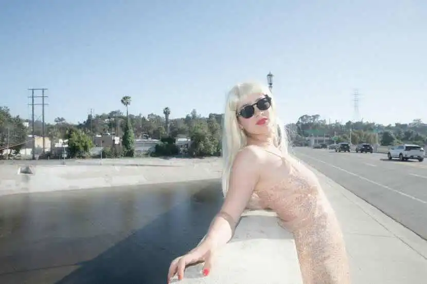 Beautiful woman in sunglasses on sunny roadside.