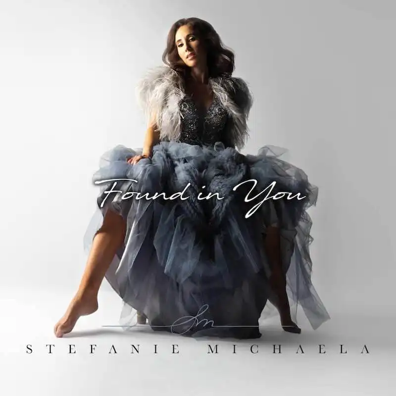 Elegant woman in glamorous evening gown with fur accents, promotional image for Stefanie Michaela's music album, LGBTQ+ friendly, romantic, stylish.
