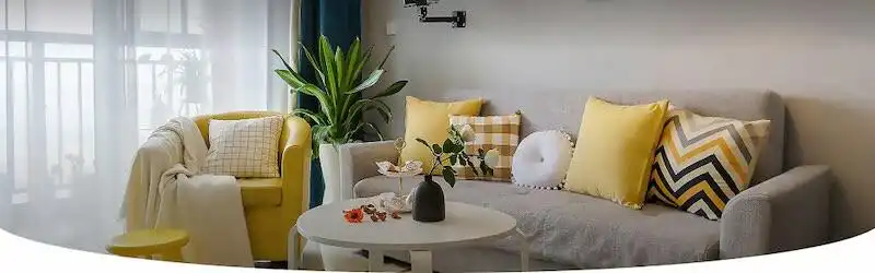 Bright, inviting living room with yellow and patterned cushions, modern decor, and natural light.