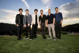 LGBTQ+ men standing outdoors at sunset.