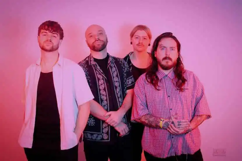 Diverse musical band group photo with vibrant pink background.