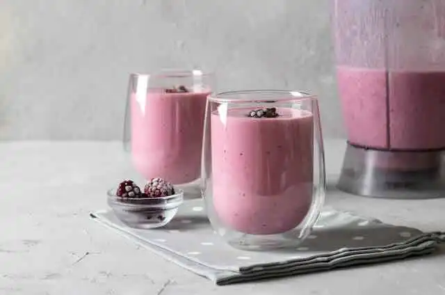 Delicious pink berry smoothies in glasses topped with berries, perfect for a healthy snack or breakfast.