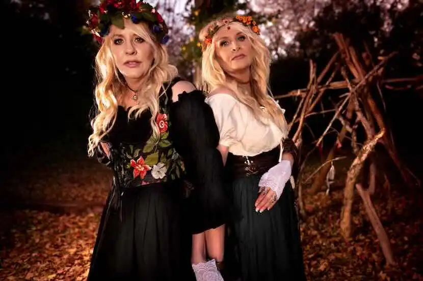 Beautiful women wearing floral crowns in a vibrant fall forest setting.