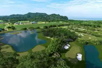 Scenic golf course with lakes and lush greenery near the coast, perfect for relaxation and outdoor activities.