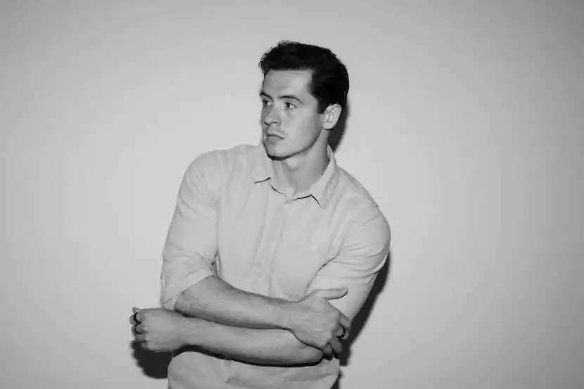 Male model in casual shirt looking away, black and white photo.