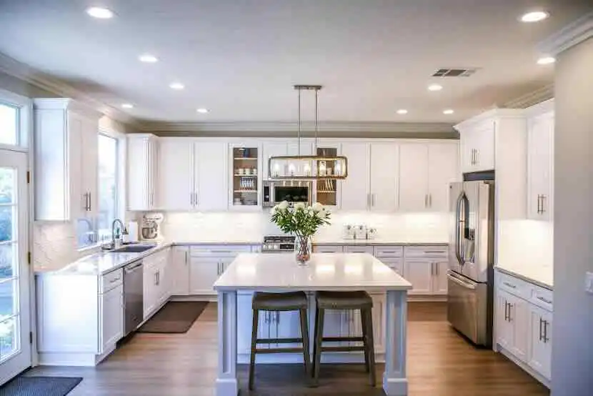 Bright, airy kitchen with white cabinets and stainless steel appliances.