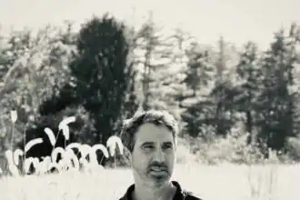 Male in casual black polo shirt outdoors.