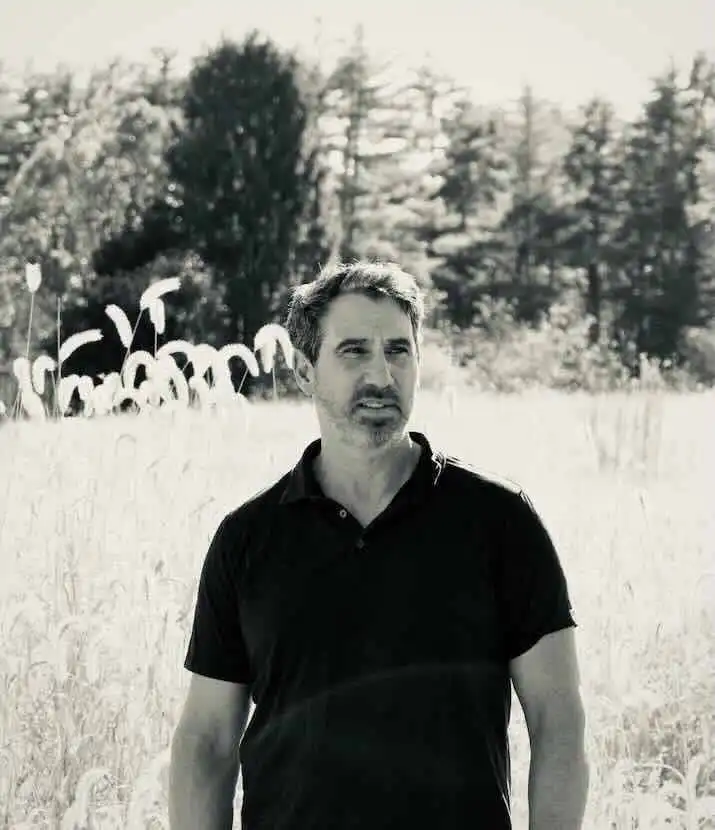 Male in casual black polo shirt outdoors.