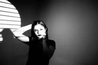 Elegant woman with dramatic lighting and shadows, emphasizing mood and allure.