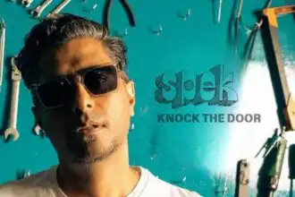 Man wearing sunglasses in workshop.