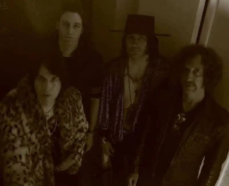 Dark, moody photo of a rock band with bold fashion, capturing alternative music vibe.