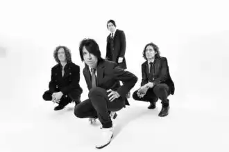 Vegan magazine photo of diverse band members in stylish black suits, posing confidently for a modern, edgy look.