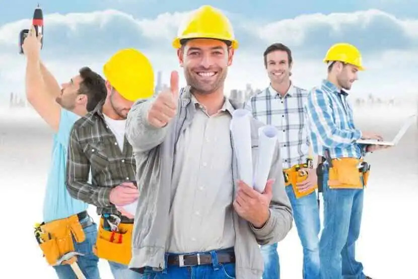 Handsome construction team with helmets and tools.