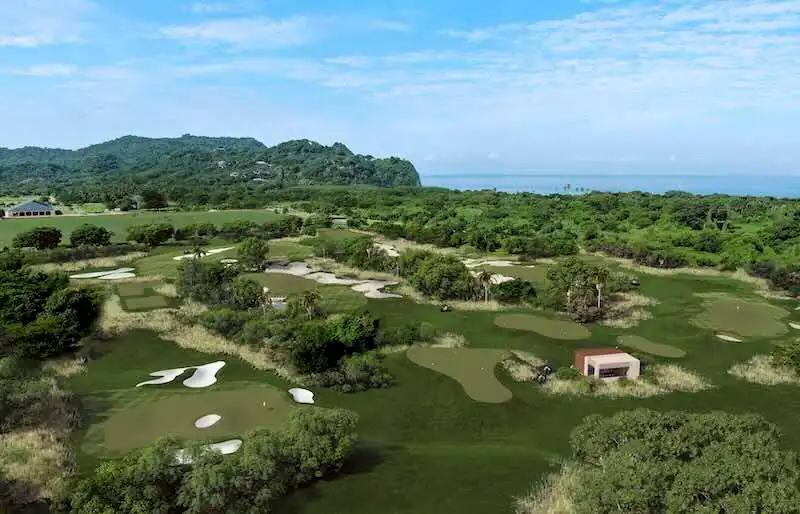 Beautiful tropical golf course surrounded by lush greenery with ocean views.