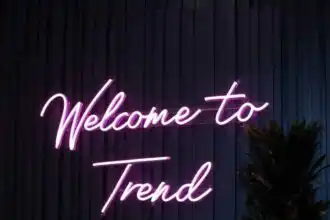 Neon sign reading "Welcome to Trend" against dark wall, stylish decor for modern venues.