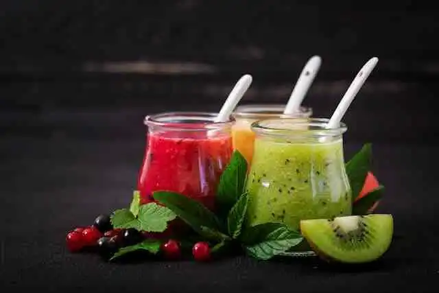 Bright and colorful fruit smoothies with berries, citrus, and greens.
