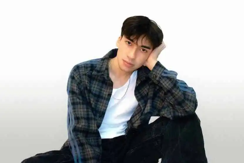 Young man in casual plaid shirt for LGBTQ lifestyle and fashion coverage.