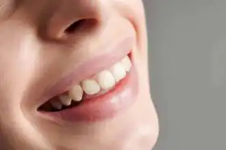Close-up of a woman's joyful smile showcasing healthy, white teeth.