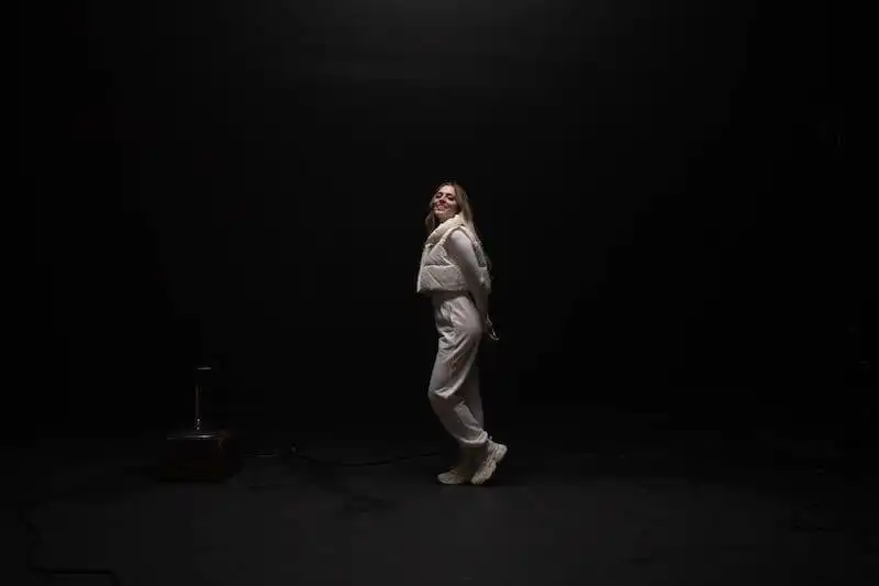 Happy woman dancing in minimalistic studio for LGBTQ+ and LGBTQ community.