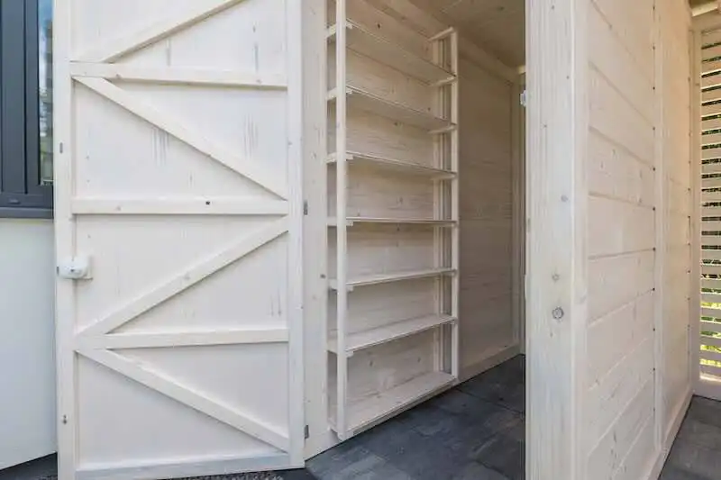 Custom wooden storage shed with shelving for outdoor organizational space.