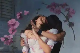 Two women hugging passionately, celebrating love and connection, with pink flowers in the background.