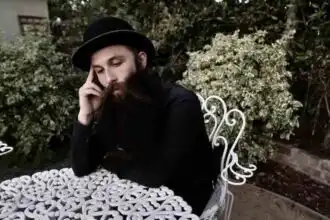 Handsome man with beard wearing a hat outdoors.