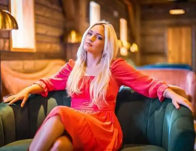 Elegant woman in red dress at cozy lounge.