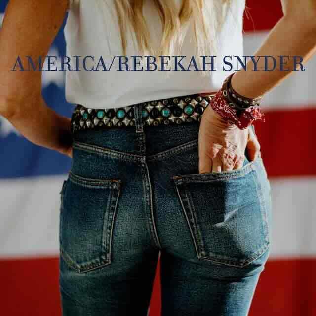 Close-up of woman’s hip and hand with American flag in background, casual style, love for country.