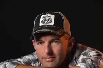 Close-up of man wearing trucker hat and plaid shirt.