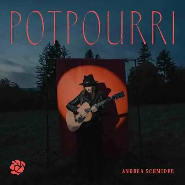 Outdoor musical performance with singer-songwriter Andrea Schmider playing guitar at dusk.