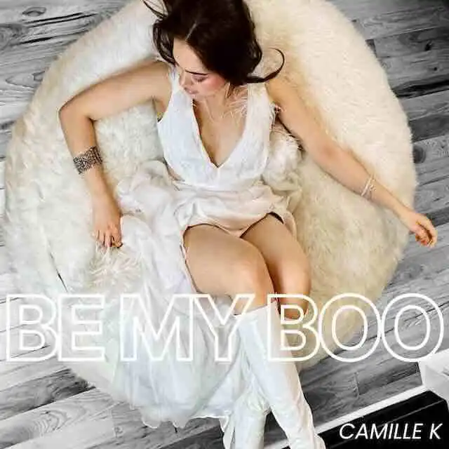 A woman relaxing on a cozy chair, embracing self-love and confidence in an intimate setting.