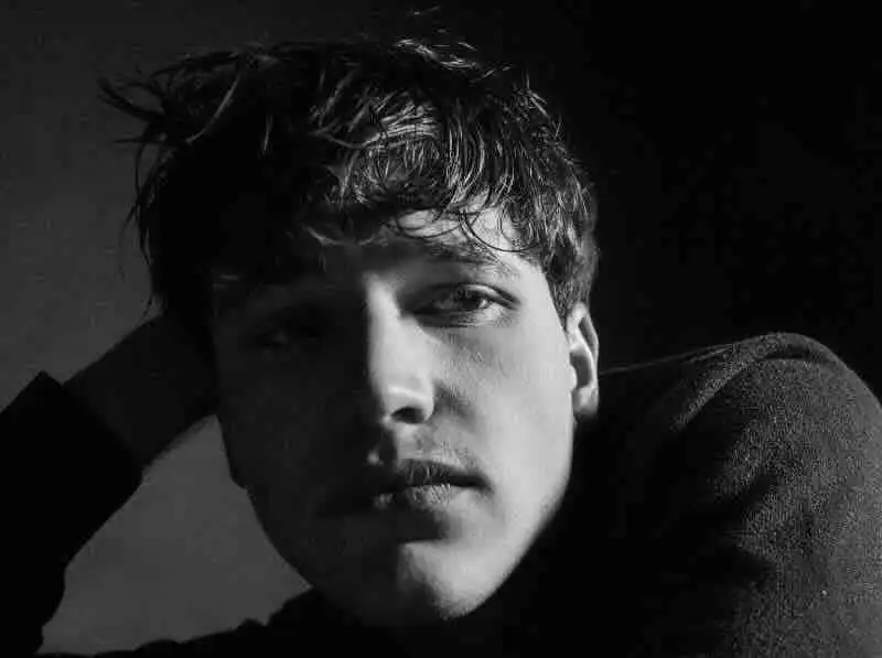 Stunning black-and-white portrait of a young man with captivating eyes, emphasizing mood and emotion. Perfect for fashion, portrait, or artistic photography.