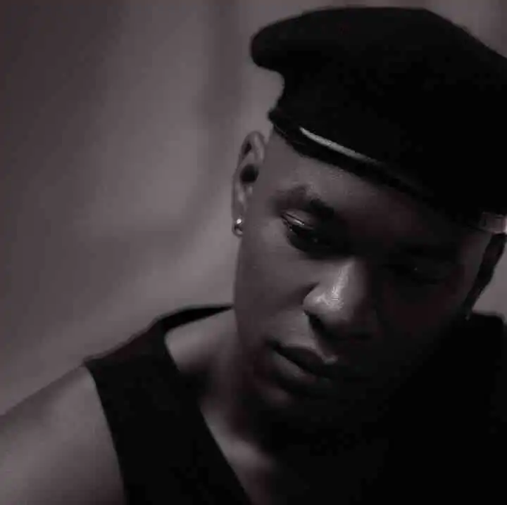 Close-up of a thoughtful Black woman in a police or military uniform cap, emphasizing strength and resilience.