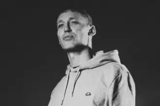 Young man in hoodie looks confident and relaxed.