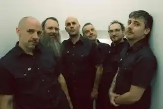 Group of six men in black shirts posing for photo.