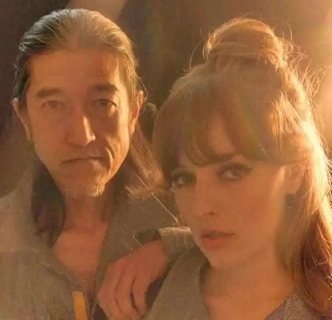 Close-up of a man and woman in warm lighting, capturing a candid, sensual moment.