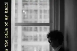 Silhouette of a man with glasses reading a book near a window, black and white photo.
