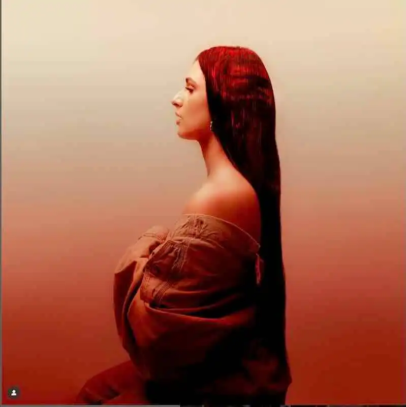 Elegant woman with long, dark hair in profile shot.