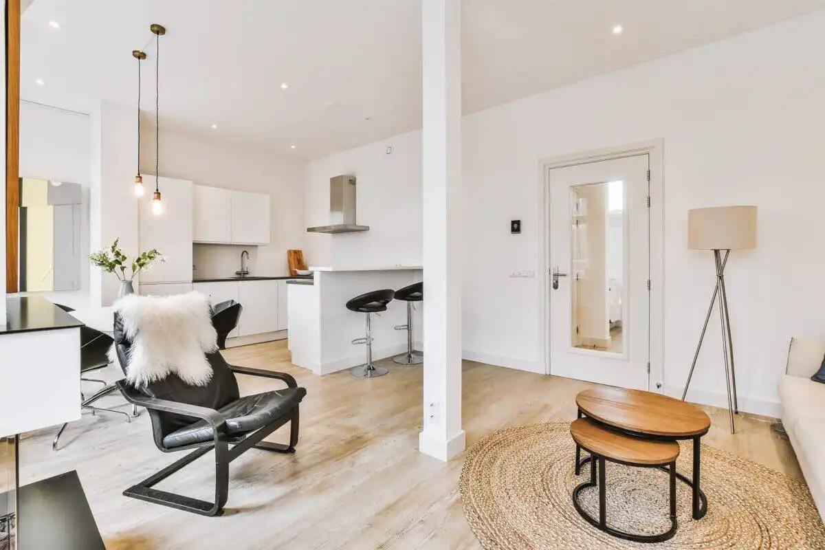 Bright, airy apartment with white walls, stylish furniture, and natural wood accents, ideal for modern living.