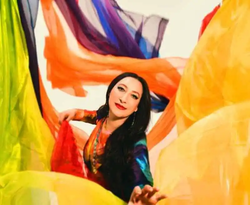 Colorful abstract art featuring a woman surrounded by flowing, multicolored fabrics.