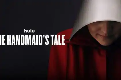 Close-up of the Handmaid's Tale character wearing a red cloak and white bonnet.