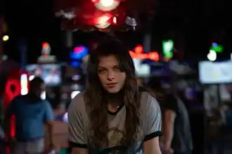 Young woman playing pool in a vibrant bar setting.