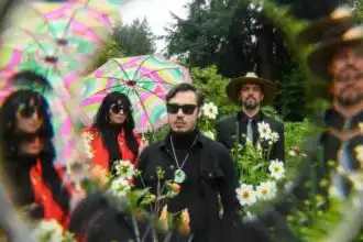 Vibrant outdoor photo featuring a diverse group of friends with umbrellas and flowers, capturing a lively and colorful garden scene.