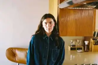 Young woman in casual denim jacket in modern kitchen setting.