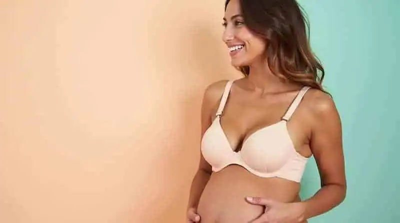 Beautiful woman smiling in a cream-colored nursing bra, promoting comfort and style for new mothers.