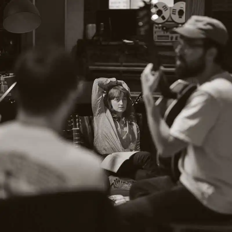 Young woman being interviewed in a recording studio.