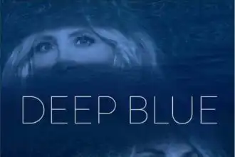 Woman's face submerged in water with deep blue hues, evoking emotion and introspection.