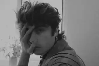 Close-up of a young man with hand on face, black and white style.