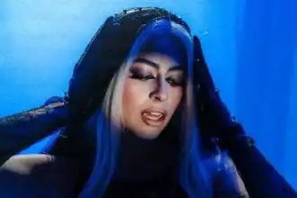 Stunning dark fantasy model with vibrant blue hair and dramatic makeup for LGBTQ+ and fashion enthusiasts.